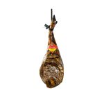 Jamón Ibérico de Bellota colgado con etiqueta roja Enrique, representando los Jamones Ibéricos de Bellota y Embutidos Gourmet de calidad