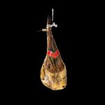 Paleta de Bellota colgada con cuerda blanca y etiqueta roja, representativa de los Jamones Ibéricos de Bellota y Embutidos Gourmet